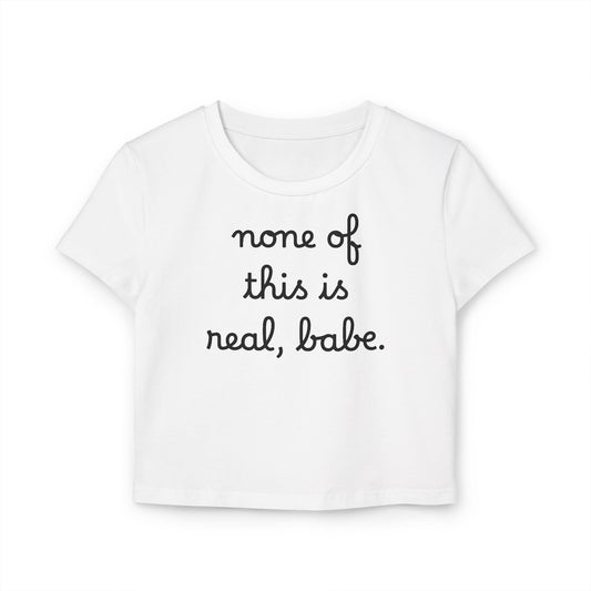 Baby Tee — "none of this is real, babe." Cropped Graphic Tee