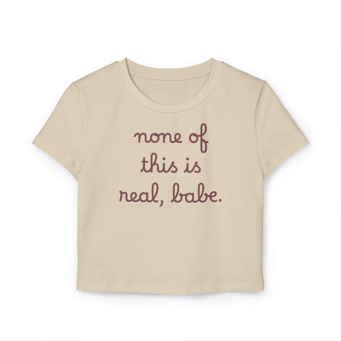 Baby Tee — "none of this is real, babe." Cropped Graphic Tee